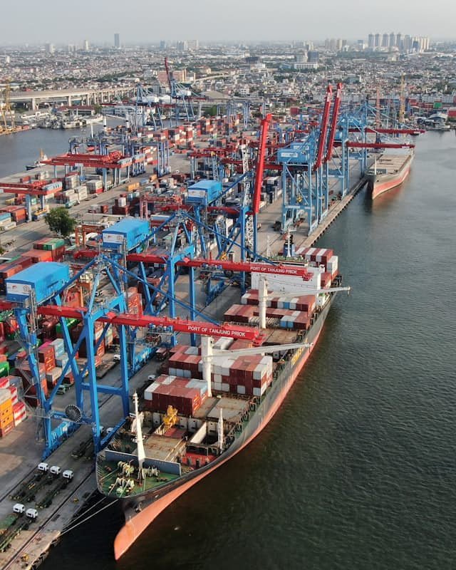 Aerial view of a container port, with a cargo ship being loaded at the dock